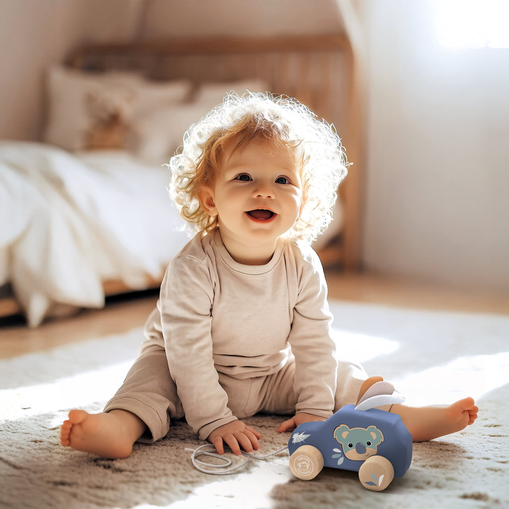 Child playing with a toy car on a carpeted floor