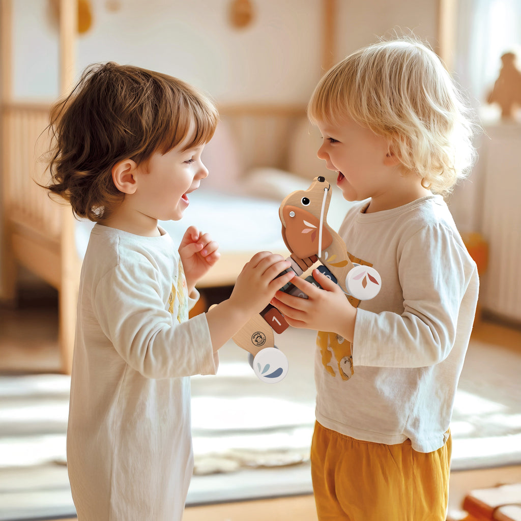 Two children playing with a toy in a bright, sunlit room.